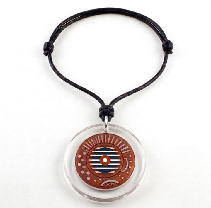 Front view of an orange and white and blue Celestia acrylic and mixed media pendant necklace. A handcrafted necklace featuring a 2 ½ inch round pendant. The pendant is mixed media and acrylic and has intricate patterns and lines and small circular indentations and  horizontal blue and white stripes and a central white dot. The pendant is hung on a black, 26-inch adjustable cord with sliding knots.  Shop at www.andreaandme.com
